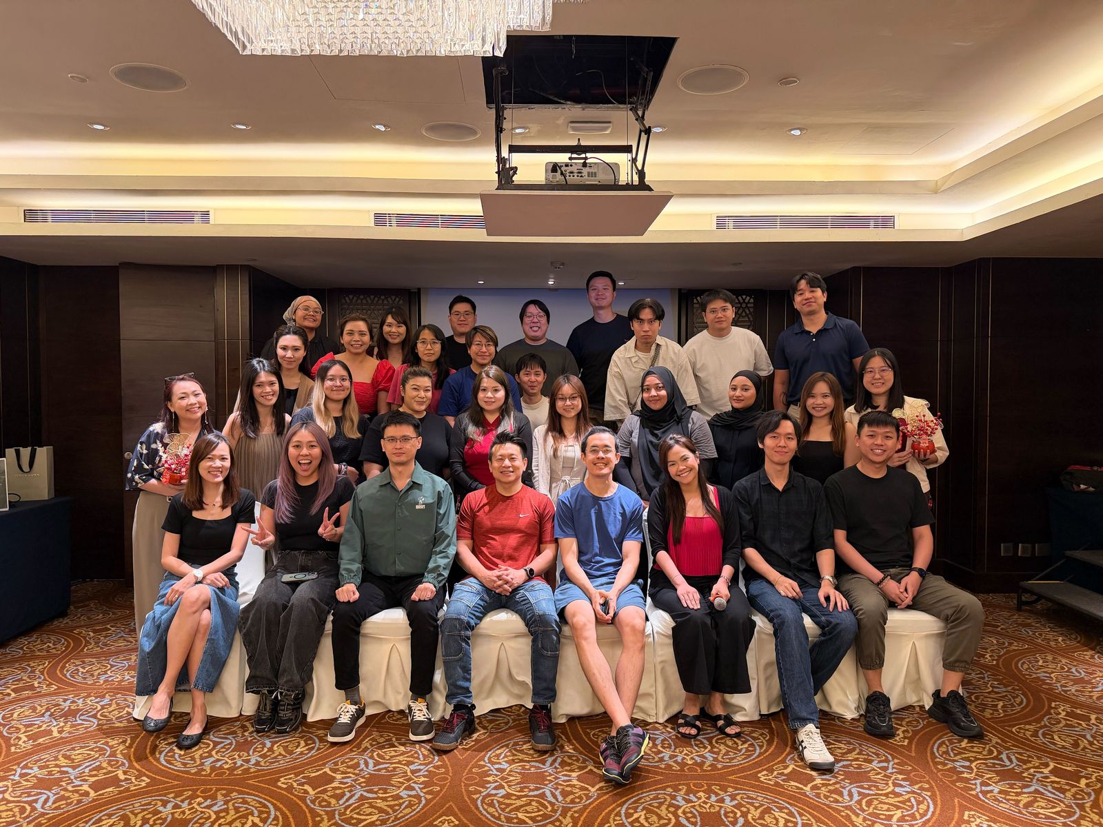 Alvin with his team, about forty people posed together in a function room.