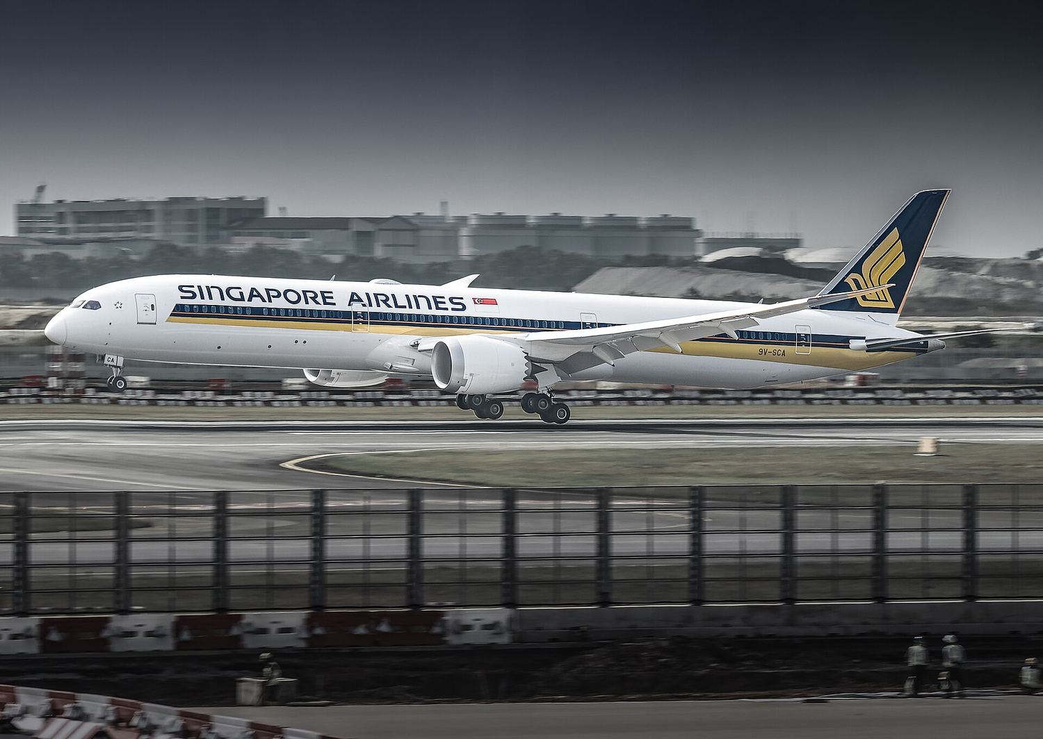A Singapore Airlines Boeing 787 on a wet runway.